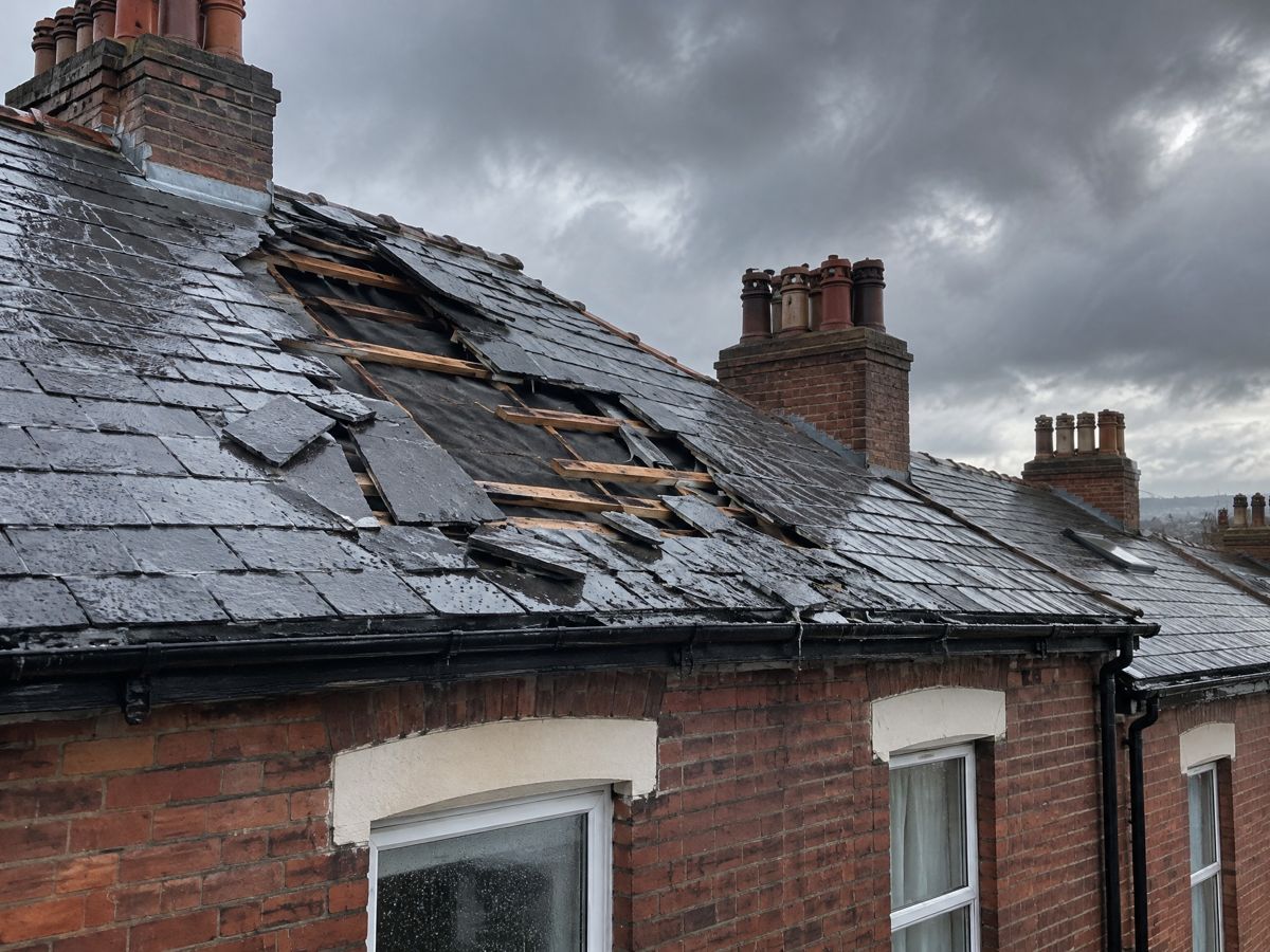 Missing slates on a storm-damaged terraced roof